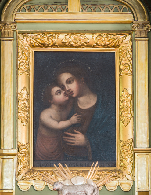 Obraz ołtarzowy z wizerunkiem Matki Boskiej w półpostaci przytulającej twarz do Dzieciątka Jezus, które ją obejmuje.