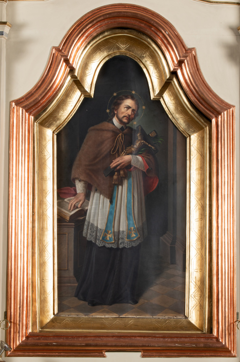 Obraz ukazujący św. Jana Nepomucena w całej postaci, ubranego w strój kanonika. Lewą ręką podtrzymuje krucyfiks, prawą kładzie na książce leżącej na postumencie, obok niego. Scena ukazana we wnętrzu z widocznymi filarami i posadzką w kratę.