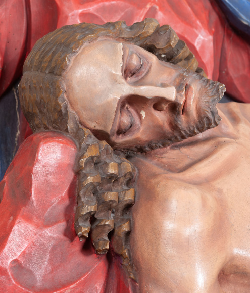 Fragment rzeźby „Pieta”, ukazujący głowę Chrystusa, bezwiednie leżącą na kolanach Marii.