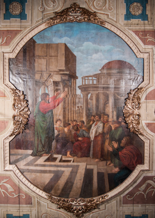 Zdjęcie stropu kościoła w Bodzanowie, z obrazem ujętym ramą, przedstawiającym scenę kazania św. Piotra w Atenach, na tle architektury.