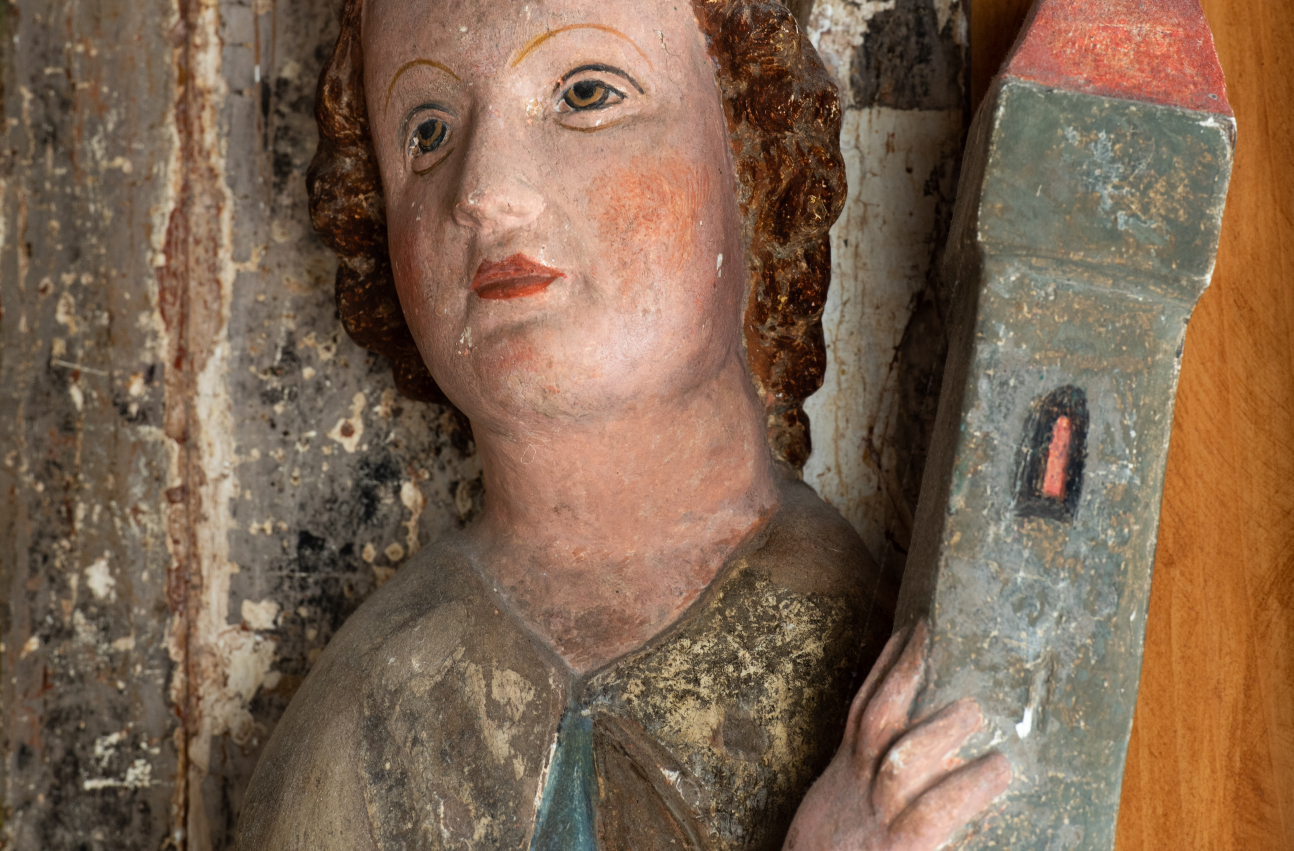 Zdjęcie 17. Fragment rzeźby świętej Barbry ukazujący ją w popiersi z wieżą w lewej dłoni.