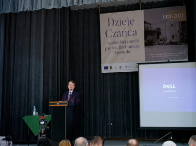 Za mównicą profesor Stanisław Sroka na tle baneru z napisem "Dzieje Czańca"