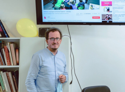 Józef Skrabski stoi w Pracowni Inwentaryzacji i Digitalizacji Zabytków poniżej monitora.