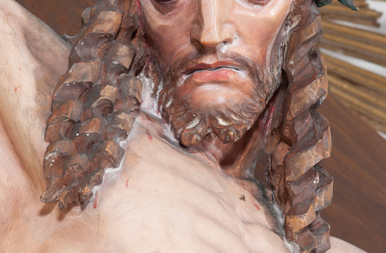 Fragment rzeźby „Chrystus Ukrzyżowany” w kościele w Kamieniu. Widok na twarz zmarłego Chrystusa, z głową w koronie cierniowej, oraz na klatkę piersiową z raną w boku.