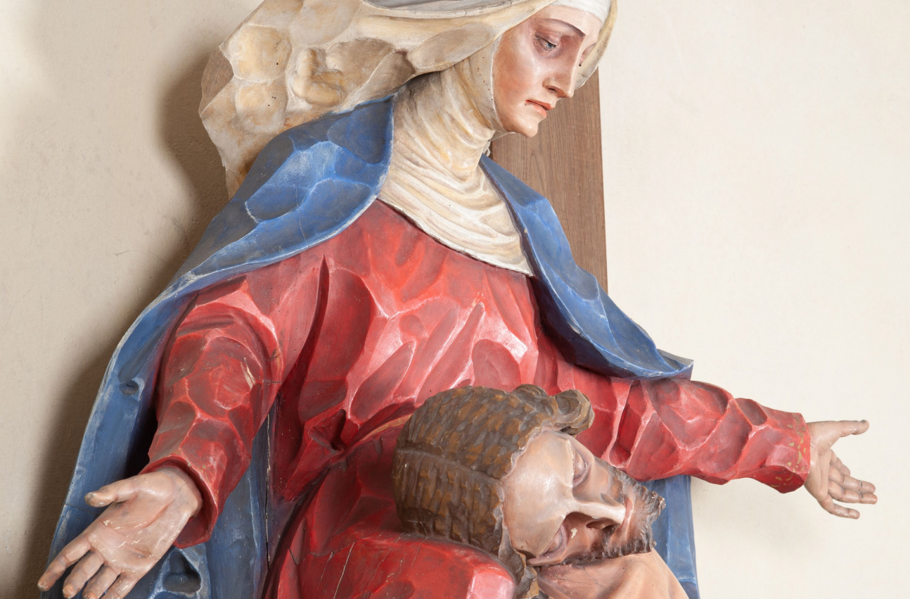Fragment grupy rzeźbiarskiej „Pieta” w kościele w Kamieniu. Widok z boku na Marię i leżące na jej kolanach ciało Chrystusa.