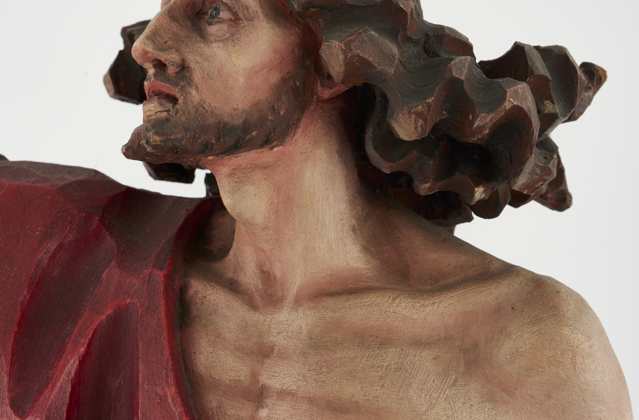 Fragment rzeźby „Chrystus Zmartwychwstały”, ukazujący Chrystusa w popiersiu, z rozwianymi włosami.