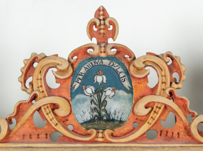 Emblemat na szafie zakrystyjnej przedstawiający gałązkę białej lilii. U góry szarfa z napisem „PER ARDVA DVLCIS”.