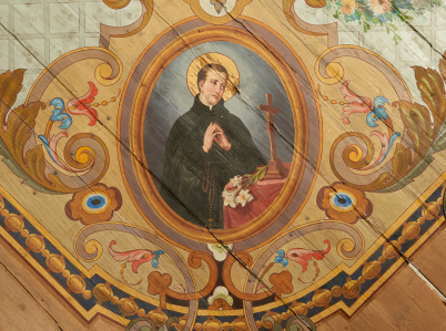 Zdjęcie fragmentu polichromii kościoła w Trzemeśni z owalnym medalionem z półpostacią św. Stanisława Kostki modlącego się przed krucyfiksem, z lilią.
