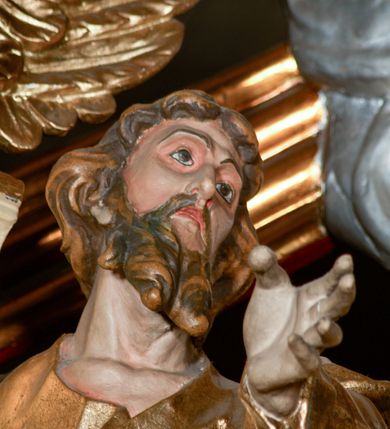 Zdjęcie nr 51: Przyścienny architektoniczny ołtarz jednoosiowy i jednokondygnacjowy, ze zwieńczeniem. Ołtarz jest murowany, w formie prostopadłościennej, skrzyni z portatylem i drewnianym antepedium. Nastawa ołtarzowa jest osadzona na dwóch flankujących mensę wysokich, ukośnych cokołach. Część środkową retabulum ujmuje para skośnie ustawionych filarów, pilastrów i kolumn o korynckich kapitelach wspierających subtelnie wyłamujące się ponad nimi, przerwane w partii architrawu i fryzu belkowanie. Zwieńczenie jest w formie przerwanego, półkolistego skośnie ustawionego przyczółka. Boki cokołu retabulum zdobi motyw wazonów. Pole ujętego profilowaną, złoconą ramą antepedium wypełniają trzy okrągłe medaliony, środkowy z monogramem imienia Jezus, w dwóch bocznych litery A i Ω, a w narożach motywy akantu. Część środkowa retabulum jest zaaranżowana w formie wnęki w kształcie stojącego prostokąta zamkniętego nadwieszonym łukiem półkolistym, ujętej profilowaną, złocona ramą, której dłuższe boki zdobią różane gałązki z kwiatami. Pośrodku belkowania znajduje się fantazyjny, rocaille'owy kartusz. Boki zwieńczenia zdobią figury czterech ewangelistów wraz z ich symbolami od prawej: św. Marek z lwem, św. Jan z orłem, św. Mateusz (brak), św. Łukasz z wołem. Pośrodku zwieńczenia znajduje się promienista gloria o alternowanych promieniach, z wieńcem srebrzonych obłoków oraz z trójkątem z okiem Opatrzności Bożej w centrum. Po bokach retabulum umieszczono figury św. Wojciecha po prawej i św. Stanisława po lewej stronie. 
Tabernakulum jest w formie niewielkiej, prostopadłościennej skrzynki obitej miedzianą blachą z trybowanym chryzmonem na drzwiczkach i mniejszymi scenami figuralnymi w obramowaniu.

 Struktura ołtarza utrzymana jest w kolorze kremowym, detal architektoniczny i ornamentyka są złocone.   

