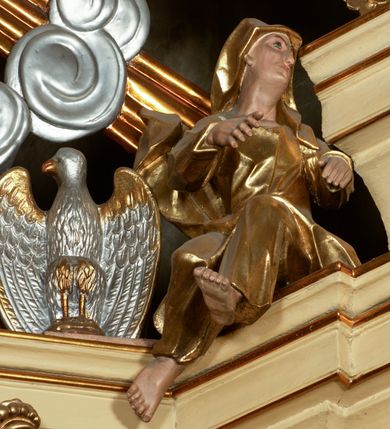 Zdjęcie nr 10: Przyścienny architektoniczny ołtarz jednoosiowy i jednokondygnacjowy, ze zwieńczeniem. Ołtarz jest murowany, w formie prostopadłościennej, skrzyni z portatylem i drewnianym antepedium. Nastawa ołtarzowa jest osadzona na dwóch flankujących mensę wysokich, ukośnych cokołach. Część środkową retabulum ujmuje para skośnie ustawionych filarów, pilastrów i kolumn o korynckich kapitelach wspierających subtelnie wyłamujące się ponad nimi, przerwane w partii architrawu i fryzu belkowanie. Zwieńczenie jest w formie przerwanego, półkolistego skośnie ustawionego przyczółka. Boki cokołu retabulum zdobi motyw wazonów. Pole ujętego profilowaną, złoconą ramą antepedium wypełniają trzy okrągłe medaliony, środkowy z monogramem imienia Jezus, w dwóch bocznych litery A i Ω, a w narożach motywy akantu. Część środkowa retabulum jest zaaranżowana w formie wnęki w kształcie stojącego prostokąta zamkniętego nadwieszonym łukiem półkolistym, ujętej profilowaną, złocona ramą, której dłuższe boki zdobią różane gałązki z kwiatami. Pośrodku belkowania znajduje się fantazyjny, rocaille'owy kartusz. Boki zwieńczenia zdobią figury czterech ewangelistów wraz z ich symbolami od prawej: św. Marek z lwem, św. Jan z orłem, św. Mateusz (brak), św. Łukasz z wołem. Pośrodku zwieńczenia znajduje się promienista gloria o alternowanych promieniach, z wieńcem srebrzonych obłoków oraz z trójkątem z okiem Opatrzności Bożej w centrum. Po bokach retabulum umieszczono figury św. Wojciecha po prawej i św. Stanisława po lewej stronie. 
Tabernakulum jest w formie niewielkiej, prostopadłościennej skrzynki obitej miedzianą blachą z trybowanym chryzmonem na drzwiczkach i mniejszymi scenami figuralnymi w obramowaniu.

 Struktura ołtarza utrzymana jest w kolorze kremowym, detal architektoniczny i ornamentyka są złocone.   

