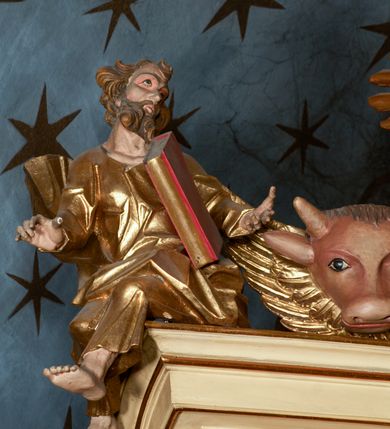 Zdjęcie nr 24: Przyścienny architektoniczny ołtarz jednoosiowy i jednokondygnacjowy, ze zwieńczeniem. Ołtarz jest murowany, w formie prostopadłościennej, skrzyni z portatylem i drewnianym antepedium. Nastawa ołtarzowa jest osadzona na dwóch flankujących mensę wysokich, ukośnych cokołach. Część środkową retabulum ujmuje para skośnie ustawionych filarów, pilastrów i kolumn o korynckich kapitelach wspierających subtelnie wyłamujące się ponad nimi, przerwane w partii architrawu i fryzu belkowanie. Zwieńczenie jest w formie przerwanego, półkolistego skośnie ustawionego przyczółka. Boki cokołu retabulum zdobi motyw wazonów. Pole ujętego profilowaną, złoconą ramą antepedium wypełniają trzy okrągłe medaliony, środkowy z monogramem imienia Jezus, w dwóch bocznych litery A i Ω, a w narożach motywy akantu. Część środkowa retabulum jest zaaranżowana w formie wnęki w kształcie stojącego prostokąta zamkniętego nadwieszonym łukiem półkolistym, ujętej profilowaną, złocona ramą, której dłuższe boki zdobią różane gałązki z kwiatami. Pośrodku belkowania znajduje się fantazyjny, rocaille'owy kartusz. Boki zwieńczenia zdobią figury czterech ewangelistów wraz z ich symbolami od prawej: św. Marek z lwem, św. Jan z orłem, św. Mateusz (brak), św. Łukasz z wołem. Pośrodku zwieńczenia znajduje się promienista gloria o alternowanych promieniach, z wieńcem srebrzonych obłoków oraz z trójkątem z okiem Opatrzności Bożej w centrum. Po bokach retabulum umieszczono figury św. Wojciecha po prawej i św. Stanisława po lewej stronie. 
Tabernakulum jest w formie niewielkiej, prostopadłościennej skrzynki obitej miedzianą blachą z trybowanym chryzmonem na drzwiczkach i mniejszymi scenami figuralnymi w obramowaniu.

 Struktura ołtarza utrzymana jest w kolorze kremowym, detal architektoniczny i ornamentyka są złocone.   

