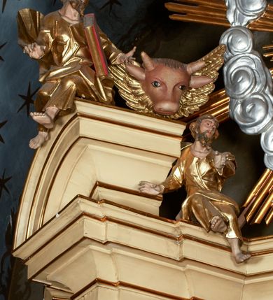 Zdjęcie nr 13: Przyścienny architektoniczny ołtarz jednoosiowy i jednokondygnacjowy, ze zwieńczeniem. Ołtarz jest murowany, w formie prostopadłościennej, skrzyni z portatylem i drewnianym antepedium. Nastawa ołtarzowa jest osadzona na dwóch flankujących mensę wysokich, ukośnych cokołach. Część środkową retabulum ujmuje para skośnie ustawionych filarów, pilastrów i kolumn o korynckich kapitelach wspierających subtelnie wyłamujące się ponad nimi, przerwane w partii architrawu i fryzu belkowanie. Zwieńczenie jest w formie przerwanego, półkolistego skośnie ustawionego przyczółka. Boki cokołu retabulum zdobi motyw wazonów. Pole ujętego profilowaną, złoconą ramą antepedium wypełniają trzy okrągłe medaliony, środkowy z monogramem imienia Jezus, w dwóch bocznych litery A i Ω, a w narożach motywy akantu. Część środkowa retabulum jest zaaranżowana w formie wnęki w kształcie stojącego prostokąta zamkniętego nadwieszonym łukiem półkolistym, ujętej profilowaną, złocona ramą, której dłuższe boki zdobią różane gałązki z kwiatami. Pośrodku belkowania znajduje się fantazyjny, rocaille&#039;owy kartusz. Boki zwieńczenia zdobią figury czterech ewangelistów wraz z ich symbolami od prawej: św. Marek z lwem, św. Jan z orłem, św. Mateusz (brak), św. Łukasz z wołem. Pośrodku zwieńczenia znajduje się promienista gloria o alternowanych promieniach, z wieńcem srebrzonych obłoków oraz z trójkątem z okiem Opatrzności Bożej w centrum. Po bokach retabulum umieszczono figury św. Wojciecha po prawej i św. Stanisława po lewej stronie. 
Tabernakulum jest w formie niewielkiej, prostopadłościennej skrzynki obitej miedzianą blachą z trybowanym chryzmonem na drzwiczkach i mniejszymi scenami figuralnymi w obramowaniu.

 Struktura ołtarza utrzymana jest w kolorze kremowym, detal architektoniczny i ornamentyka są złocone.   

