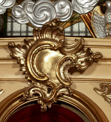 Zdjęcie nr 3: Przyścienny architektoniczny ołtarz jednoosiowy i jednokondygnacjowy, ze zwieńczeniem. Ołtarz jest murowany, w formie prostopadłościennej, skrzyni z portatylem i drewnianym antepedium. Nastawa ołtarzowa jest osadzona na dwóch flankujących mensę wysokich, ukośnych cokołach. Część środkową retabulum ujmuje para skośnie ustawionych filarów, pilastrów i kolumn o korynckich kapitelach wspierających subtelnie wyłamujące się ponad nimi, przerwane w partii architrawu i fryzu belkowanie. Zwieńczenie jest w formie przerwanego, półkolistego skośnie ustawionego przyczółka. Boki cokołu retabulum zdobi motyw wazonów. Pole ujętego profilowaną, złoconą ramą antepedium wypełniają trzy okrągłe medaliony, środkowy z monogramem imienia Jezus, w dwóch bocznych litery A i Ω, a w narożach motywy akantu. Część środkowa retabulum jest zaaranżowana w formie wnęki w kształcie stojącego prostokąta zamkniętego nadwieszonym łukiem półkolistym, ujętej profilowaną, złocona ramą, której dłuższe boki zdobią różane gałązki z kwiatami. Pośrodku belkowania znajduje się fantazyjny, rocaille'owy kartusz. Boki zwieńczenia zdobią figury czterech ewangelistów wraz z ich symbolami od prawej: św. Marek z lwem, św. Jan z orłem, św. Mateusz (brak), św. Łukasz z wołem. Pośrodku zwieńczenia znajduje się promienista gloria o alternowanych promieniach, z wieńcem srebrzonych obłoków oraz z trójkątem z okiem Opatrzności Bożej w centrum. Po bokach retabulum umieszczono figury św. Wojciecha po prawej i św. Stanisława po lewej stronie. 
Tabernakulum jest w formie niewielkiej, prostopadłościennej skrzynki obitej miedzianą blachą z trybowanym chryzmonem na drzwiczkach i mniejszymi scenami figuralnymi w obramowaniu.

 Struktura ołtarza utrzymana jest w kolorze kremowym, detal architektoniczny i ornamentyka są złocone.   

