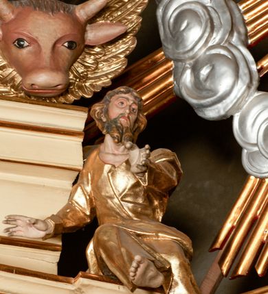 Zdjęcie nr 50: Przyścienny architektoniczny ołtarz jednoosiowy i jednokondygnacjowy, ze zwieńczeniem. Ołtarz jest murowany, w formie prostopadłościennej, skrzyni z portatylem i drewnianym antepedium. Nastawa ołtarzowa jest osadzona na dwóch flankujących mensę wysokich, ukośnych cokołach. Część środkową retabulum ujmuje para skośnie ustawionych filarów, pilastrów i kolumn o korynckich kapitelach wspierających subtelnie wyłamujące się ponad nimi, przerwane w partii architrawu i fryzu belkowanie. Zwieńczenie jest w formie przerwanego, półkolistego skośnie ustawionego przyczółka. Boki cokołu retabulum zdobi motyw wazonów. Pole ujętego profilowaną, złoconą ramą antepedium wypełniają trzy okrągłe medaliony, środkowy z monogramem imienia Jezus, w dwóch bocznych litery A i Ω, a w narożach motywy akantu. Część środkowa retabulum jest zaaranżowana w formie wnęki w kształcie stojącego prostokąta zamkniętego nadwieszonym łukiem półkolistym, ujętej profilowaną, złocona ramą, której dłuższe boki zdobią różane gałązki z kwiatami. Pośrodku belkowania znajduje się fantazyjny, rocaille&#039;owy kartusz. Boki zwieńczenia zdobią figury czterech ewangelistów wraz z ich symbolami od prawej: św. Marek z lwem, św. Jan z orłem, św. Mateusz (brak), św. Łukasz z wołem. Pośrodku zwieńczenia znajduje się promienista gloria o alternowanych promieniach, z wieńcem srebrzonych obłoków oraz z trójkątem z okiem Opatrzności Bożej w centrum. Po bokach retabulum umieszczono figury św. Wojciecha po prawej i św. Stanisława po lewej stronie. 
Tabernakulum jest w formie niewielkiej, prostopadłościennej skrzynki obitej miedzianą blachą z trybowanym chryzmonem na drzwiczkach i mniejszymi scenami figuralnymi w obramowaniu.

 Struktura ołtarza utrzymana jest w kolorze kremowym, detal architektoniczny i ornamentyka są złocone.   

