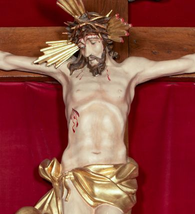 Zdjęcie nr 1: Drewniana, pełnoplastyczna, polichromowana figura Chrystusa Ukrzyżowanego w typie Christo vivo na drewnianym krzyżu znajduje się we wnęce części środkowej ołtarza głównego w kościele pw. Wszystkich Świętych w Babicach. Sylwetkę charakteryzuje wyrazista muskulatura ciała. Zwróconą w trzech czwartych w lewo głowę, lekko pochyloną w dół, charakteryzuje pociągła twarz o wyrazistych rysach, lekko przymkniętych oczach i z krótkim, rozdwojonym na końcu zarostem. Długie, brązowe, skręcone w pukle włosy opadają na plecy i prawe ramię. Głowę wieńczy złocona, cierniowa korona i okalają trzy wiązki złoconych promieni. Ramiona są w płytkim, T-kształtnym zwisie, klatka piersiowa z zaznaczoną linią żeber. Biodra osłania krótkie, złocone, przewiązane sznurem, mocno fałdowane perizonium z długim, rozwianym zwisem na prawym boku. Nogi przybite są jednym gwoździem. Na czole, torsie, rękach i stopach widoczne są strużki krwi. W górnej części pionowej belki krzyża znajduje się srebrzony titulus ze złoconym napisem: INRI. Wnęka przesłaniana jest zasuwą z przedstawieniem Wszystkich Świętych.         

  