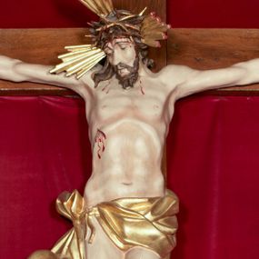 Zdjęcie nr 1: Drewniana, pełnoplastyczna, polichromowana figura Chrystusa Ukrzyżowanego w typie Christo vivo na drewnianym krzyżu znajduje się we wnęce części środkowej ołtarza głównego w kościele pw. Wszystkich Świętych w Babicach. Sylwetkę charakteryzuje wyrazista muskulatura ciała. Zwróconą w trzech czwartych w lewo głowę, lekko pochyloną w dół, charakteryzuje pociągła twarz o wyrazistych rysach, lekko przymkniętych oczach i z krótkim, rozdwojonym na końcu zarostem. Długie, brązowe, skręcone w pukle włosy opadają na plecy i prawe ramię. Głowę wieńczy złocona, cierniowa korona i okalają trzy wiązki złoconych promieni. Ramiona są w płytkim, T-kształtnym zwisie, klatka piersiowa z zaznaczoną linią żeber. Biodra osłania krótkie, złocone, przewiązane sznurem, mocno fałdowane perizonium z długim, rozwianym zwisem na prawym boku. Nogi przybite są jednym gwoździem. Na czole, torsie, rękach i stopach widoczne są strużki krwi. W górnej części pionowej belki krzyża znajduje się srebrzony titulus ze złoconym napisem: INRI. Wnęka przesłaniana jest zasuwą z przedstawieniem Wszystkich Świętych.         

  