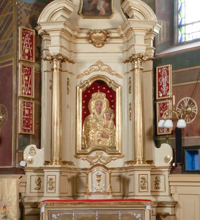 Zdjęcie nr 2: Ołtarz przyścienny, narożny, usytuowany po prawej stronie, w pierwszym od prezbiterium przęśle nawy, przy ścianie tęczowej. Architektoniczny, jednokondygnacyjny ze zwieńczeniem. Mensa murowana, prostopadłościenna, w typie skrzyniowym, z relikwiami nieznanego z imienia jednego ze świętych męczenników. Antepedium z blachy w drewnianej ramie, z monogramem imienia Jezus w centrum. Niewielkie, drewniane tabernakulum architektoniczne, na cokole. Jednoskrzydłowe drzwiczki zdobione płaskorzeźbionym kielichem z hostią, flankowane pilastrami o trzonach spływających wolutowo, podtrzymujących wyłamany gzyms. Nastawa ołtarzowa wsparta na flankujących mensę wysokich, dwudzielnych postumentach, dekorowanych złoconymi płycinami zdobionymi rocaille'em. Części boczne na całej wysokości ustawione ukośnie w stosunku do osi środkowej ołtarza. Wysunięte przed zdwojone pilastry z trzonami dekorowanymi rocaille'ami, kolumny o kanelowanych na całej wysokości, złoconych trzonach i kompozytowych kapitelach, dźwigają bogato profilowane, gierowane, pełne belkowanie, wyłamane na osi podpór. Wieńczy je przerwany, półkolisty przyczółek. W polu nastawy złocona, profilowana rama o kształcie stojącego, podciętego półkoliście u podstawy prostokąta zamkniętego łukiem wklęsło-wypukłym z uskokiem. Poniżej i powyżej złocone aplikacje w formie mocno przestylizowanych liści akantu i muszli palmetowych. Wewnątrz wysuwane dwa obrazy: z Matką Boską Różańcową w sukience i ze św. Anną (obecnie niedostępny – popsuty mechanizm wysuwający). Na belkowaniu osadzony rocaille'owy kartusz. Zwieńczenie o wykrojonych wolutowo bokach zamknięte łukiem wklęsło-wypukłym, utworzonym przez dwie przeciwstawne woluty. U szczytu złocona, ażurowo wycinana muszla palmetowa. W polu zwieńczenia obraz na płótnie ze św. Józefem i Dzieciątkiem w kształcie stojącego prostokąta o ściętych krawędziach dolnych i wklęsłych bokach, zamkniętego łukiem wklęsło-wypukłym z uskokiem. Flankują go dwie niewielkie aplikacje rocaille'owe. Na tylne postumenty cokołu spływają woluty, lewa z monogramem maryjnym. 
Ołtarz obecnie przemalowany na kremowo. Ornamenty, załamania profili, ramy, trzony kolumn są złocone.
