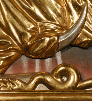 Zdjęcie nr 27: Ołtarz przyścienny, narożny, usytuowany po lewej stronie, w pierwszym od prezbiterium przęśle nawy, przy ścianie tęczowej. Architektoniczny, jednokondygnacyjny ze zwieńczeniem. Mensa murowana, prostopadłościenna, w typie skrzyniowym, z relikwiami nieznanego z imienia świętego męczennika. Antepedium z blachy w drewnianej ramie, z monogramem maryjnym w centrum. Niewielkie, drewniane tabernakulum jednodrzwiowe; lekko wypukłe drzwiczki zdobione płaskorzeźbionym kielichem z hostią wkomponowanym w złoconą płycinę zamkniętą łukiem nadwieszonym. Boki tabernakulum ujęte wolutowymi esownicami ustawionymi ukośnie w stosunku do jego lica. Zwieńczenie w formie przeciwstawnych wolut zdobionych rocaille&#039;em. Nastawa ołtarzowa wsparta na flankujących mensę wysokich, dwudzielnych postumentach dekorowanych złoconymi płycinami zdobionymi rocaille&#039;em. Części boczne na całej wysokości ustawione ukośnie w stosunku do osi środkowej ołtarza. Wysunięte przed zdwojone pilastry z trzonami dekorowanymi rocaille&#039;ami, kolumny o kanelowanych na całej wysokości, złoconych trzonach i kompozytowych kapitelach, dźwigają bogato profilowane, gierowane, pełne belkowanie, wyłamane na osi podpór. Wieńczy je przerwany, półkolisty przyczółek. W polu nastawy złocona, profilowana rama o kształcie stojącego prostokąta zamkniętego łukiem wklęsło-wypukłym z uskokiem. Na jej boku, z prawej strony nałożona złocona aplikacja kwiatowa. Wewnątrz wysuwane dwa obrazy: z Matką Boską Niepokalanie Poczętą i Aniołem Stróżem (obecnie wyjęty) pędzla Wojciecha Eljasza-Radzikowskiego. Na belkowaniu osadzony rocaille&#039;owy kartusz. Zwieńczenie o wykrojonych wolutowo bokach zamknięte łukiem wklęsło-wypukłym utworzonym przez dwie przeciwstawne woluty. U szczytu złocona, ażurowo wycinana, muszla palmetowa. W polu obraz na blasze ze św. Antonim Padewskim i Dzieciątkiem Jezus w kształcie stojącego prostokąta o ściętych krawędziach dolnych i wklęsłych bokach, zamkniętego łukiem wklęsło-wypukłym z uskokiem. Flankują go dwie, niewielkie aplikacje rocaille&#039;owe. Na tylnych postumentach cokołu dwie dużych rozmiarów, pełnoplastyczne rzeźby aniołów. Postaci stojące w silnym kontrapoście, o tanecznych, dynamicznych pozach. Ciała muskularne, odziane w bogate, złocone, mocno fałdowane szaty. Skrzydła złocone, karnacje polichromowane. Po obu bokach ołtarza niewielkie uszy utworzone z rocaille&#039;ów. Ołtarz obecnie przemalowany na kremowo. Ornamenty, załamania profili, ramy, trzony kolumn złocone.