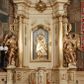 Zdjęcie nr 1: Ołtarz przyścienny, narożny, usytuowany po lewej stronie, w pierwszym od prezbiterium przęśle nawy, przy ścianie tęczowej. Architektoniczny, jednokondygnacyjny ze zwieńczeniem. Mensa murowana, prostopadłościenna, w typie skrzyniowym, z relikwiami nieznanego z imienia świętego męczennika. Antepedium z blachy w drewnianej ramie, z monogramem maryjnym w centrum. Niewielkie, drewniane tabernakulum jednodrzwiowe; lekko wypukłe drzwiczki zdobione płaskorzeźbionym kielichem z hostią wkomponowanym w złoconą płycinę zamkniętą łukiem nadwieszonym. Boki tabernakulum ujęte wolutowymi esownicami ustawionymi ukośnie w stosunku do jego lica. Zwieńczenie w formie przeciwstawnych wolut zdobionych rocaille'em. Nastawa ołtarzowa wsparta na flankujących mensę wysokich, dwudzielnych postumentach dekorowanych złoconymi płycinami zdobionymi rocaille'em. Części boczne na całej wysokości ustawione ukośnie w stosunku do osi środkowej ołtarza. Wysunięte przed zdwojone pilastry z trzonami dekorowanymi rocaille'ami, kolumny o kanelowanych na całej wysokości, złoconych trzonach i kompozytowych kapitelach, dźwigają bogato profilowane, gierowane, pełne belkowanie, wyłamane na osi podpór. Wieńczy je przerwany, półkolisty przyczółek. W polu nastawy złocona, profilowana rama o kształcie stojącego prostokąta zamkniętego łukiem wklęsło-wypukłym z uskokiem. Na jej boku, z prawej strony nałożona złocona aplikacja kwiatowa. Wewnątrz wysuwane dwa obrazy: z Matką Boską Niepokalanie Poczętą i Aniołem Stróżem (obecnie wyjęty) pędzla Wojciecha Eljasza-Radzikowskiego. Na belkowaniu osadzony rocaille'owy kartusz. Zwieńczenie o wykrojonych wolutowo bokach zamknięte łukiem wklęsło-wypukłym utworzonym przez dwie przeciwstawne woluty. U szczytu złocona, ażurowo wycinana, muszla palmetowa. W polu obraz na blasze ze św. Antonim Padewskim i Dzieciątkiem Jezus w kształcie stojącego prostokąta o ściętych krawędziach dolnych i wklęsłych bokach, zamkniętego łukiem wklęsło-wypukłym z uskokiem. Flankują go dwie, niewielkie aplikacje rocaille'owe. Na tylnych postumentach cokołu dwie dużych rozmiarów, pełnoplastyczne rzeźby aniołów. Postaci stojące w silnym kontrapoście, o tanecznych, dynamicznych pozach. Ciała muskularne, odziane w bogate, złocone, mocno fałdowane szaty. Skrzydła złocone, karnacje polichromowane. Po obu bokach ołtarza niewielkie uszy utworzone z rocaille'ów. Ołtarz obecnie przemalowany na kremowo. Ornamenty, załamania profili, ramy, trzony kolumn złocone.