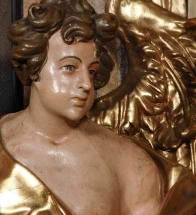 Zdjęcie nr 16: Ołtarz przyścienny, narożny, usytuowany po lewej stronie, w pierwszym od prezbiterium przęśle nawy, przy ścianie tęczowej. Architektoniczny, jednokondygnacyjny ze zwieńczeniem. Mensa murowana, prostopadłościenna, w typie skrzyniowym, z relikwiami nieznanego z imienia świętego męczennika. Antepedium z blachy w drewnianej ramie, z monogramem maryjnym w centrum. Niewielkie, drewniane tabernakulum jednodrzwiowe; lekko wypukłe drzwiczki zdobione płaskorzeźbionym kielichem z hostią wkomponowanym w złoconą płycinę zamkniętą łukiem nadwieszonym. Boki tabernakulum ujęte wolutowymi esownicami ustawionymi ukośnie w stosunku do jego lica. Zwieńczenie w formie przeciwstawnych wolut zdobionych rocaille&#039;em. Nastawa ołtarzowa wsparta na flankujących mensę wysokich, dwudzielnych postumentach dekorowanych złoconymi płycinami zdobionymi rocaille&#039;em. Części boczne na całej wysokości ustawione ukośnie w stosunku do osi środkowej ołtarza. Wysunięte przed zdwojone pilastry z trzonami dekorowanymi rocaille&#039;ami, kolumny o kanelowanych na całej wysokości, złoconych trzonach i kompozytowych kapitelach, dźwigają bogato profilowane, gierowane, pełne belkowanie, wyłamane na osi podpór. Wieńczy je przerwany, półkolisty przyczółek. W polu nastawy złocona, profilowana rama o kształcie stojącego prostokąta zamkniętego łukiem wklęsło-wypukłym z uskokiem. Na jej boku, z prawej strony nałożona złocona aplikacja kwiatowa. Wewnątrz wysuwane dwa obrazy: z Matką Boską Niepokalanie Poczętą i Aniołem Stróżem (obecnie wyjęty) pędzla Wojciecha Eljasza-Radzikowskiego. Na belkowaniu osadzony rocaille&#039;owy kartusz. Zwieńczenie o wykrojonych wolutowo bokach zamknięte łukiem wklęsło-wypukłym utworzonym przez dwie przeciwstawne woluty. U szczytu złocona, ażurowo wycinana, muszla palmetowa. W polu obraz na blasze ze św. Antonim Padewskim i Dzieciątkiem Jezus w kształcie stojącego prostokąta o ściętych krawędziach dolnych i wklęsłych bokach, zamkniętego łukiem wklęsło-wypukłym z uskokiem. Flankują go dwie, niewielkie aplikacje rocaille&#039;owe. Na tylnych postumentach cokołu dwie dużych rozmiarów, pełnoplastyczne rzeźby aniołów. Postaci stojące w silnym kontrapoście, o tanecznych, dynamicznych pozach. Ciała muskularne, odziane w bogate, złocone, mocno fałdowane szaty. Skrzydła złocone, karnacje polichromowane. Po obu bokach ołtarza niewielkie uszy utworzone z rocaille&#039;ów. Ołtarz obecnie przemalowany na kremowo. Ornamenty, załamania profili, ramy, trzony kolumn złocone.