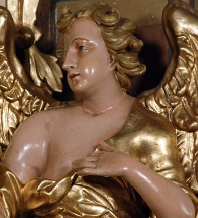 Zdjęcie nr 8: Ołtarz przyścienny, narożny, usytuowany po lewej stronie, w pierwszym od prezbiterium przęśle nawy, przy ścianie tęczowej. Architektoniczny, jednokondygnacyjny ze zwieńczeniem. Mensa murowana, prostopadłościenna, w typie skrzyniowym, z relikwiami nieznanego z imienia świętego męczennika. Antepedium z blachy w drewnianej ramie, z monogramem maryjnym w centrum. Niewielkie, drewniane tabernakulum jednodrzwiowe; lekko wypukłe drzwiczki zdobione płaskorzeźbionym kielichem z hostią wkomponowanym w złoconą płycinę zamkniętą łukiem nadwieszonym. Boki tabernakulum ujęte wolutowymi esownicami ustawionymi ukośnie w stosunku do jego lica. Zwieńczenie w formie przeciwstawnych wolut zdobionych rocaille&#039;em. Nastawa ołtarzowa wsparta na flankujących mensę wysokich, dwudzielnych postumentach dekorowanych złoconymi płycinami zdobionymi rocaille&#039;em. Części boczne na całej wysokości ustawione ukośnie w stosunku do osi środkowej ołtarza. Wysunięte przed zdwojone pilastry z trzonami dekorowanymi rocaille&#039;ami, kolumny o kanelowanych na całej wysokości, złoconych trzonach i kompozytowych kapitelach, dźwigają bogato profilowane, gierowane, pełne belkowanie, wyłamane na osi podpór. Wieńczy je przerwany, półkolisty przyczółek. W polu nastawy złocona, profilowana rama o kształcie stojącego prostokąta zamkniętego łukiem wklęsło-wypukłym z uskokiem. Na jej boku, z prawej strony nałożona złocona aplikacja kwiatowa. Wewnątrz wysuwane dwa obrazy: z Matką Boską Niepokalanie Poczętą i Aniołem Stróżem (obecnie wyjęty) pędzla Wojciecha Eljasza-Radzikowskiego. Na belkowaniu osadzony rocaille&#039;owy kartusz. Zwieńczenie o wykrojonych wolutowo bokach zamknięte łukiem wklęsło-wypukłym utworzonym przez dwie przeciwstawne woluty. U szczytu złocona, ażurowo wycinana, muszla palmetowa. W polu obraz na blasze ze św. Antonim Padewskim i Dzieciątkiem Jezus w kształcie stojącego prostokąta o ściętych krawędziach dolnych i wklęsłych bokach, zamkniętego łukiem wklęsło-wypukłym z uskokiem. Flankują go dwie, niewielkie aplikacje rocaille&#039;owe. Na tylnych postumentach cokołu dwie dużych rozmiarów, pełnoplastyczne rzeźby aniołów. Postaci stojące w silnym kontrapoście, o tanecznych, dynamicznych pozach. Ciała muskularne, odziane w bogate, złocone, mocno fałdowane szaty. Skrzydła złocone, karnacje polichromowane. Po obu bokach ołtarza niewielkie uszy utworzone z rocaille&#039;ów. Ołtarz obecnie przemalowany na kremowo. Ornamenty, załamania profili, ramy, trzony kolumn złocone.