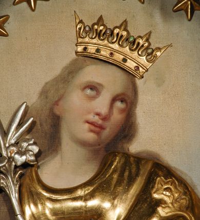 Zdjęcie nr 2: Obraz umieszczony w polu lewego ołtarza bocznego w pierwszym od prezbiterium przęśle nawy kościoła, w kształcie stojącego prostokąta zamkniętego łukiem wklęsło-wypukłym z uskokiem, w profilowanej, złoconej ramie. W centrum stojąca, ukazana frontalnie, całopostaciowo Maria w typie Niepokalanie Poczętej. Postać stojąca na półksiężycu, z głową lekko odchyloną ku górze, skierowaną w prawą stronę i rękoma skrzyżowanymi na piersi. W lewej dłoni trzyma rzeźbioną, srebrzoną lilię. Twarz drobna, okrągła z wypukłym czołem, dużymi, okrągłymi oczami wzniesionymi ku górze i niewielkimi, pełnymi ustami. Policzki zaakcentowane różem. Włosy długie, opadające na plecy w kolorze szaro-brązowym. Maria jest ubrana w obszerne, długie, rozwiane szaty nakładane na obraz drewniane, złocone. Składają się na nie płaszcz i długa suknia. Na głowie drewniana, złocona korona otwarta z rzeźbionymi szlachetnymi kamieniami. Wokół głowy okrąg z 12 drewnianych i złoconych gwiazd. W dole kompozycji płaskorzeźbiony, srebrzony półksiężyc, oraz złocone glob i wąż z jabłkiem w paszczy. Tło malowane, nieokreślonej barwy brązowo-niebieskiej, rozjaśnione wokół głowy Marii i u dołu kompozycji.