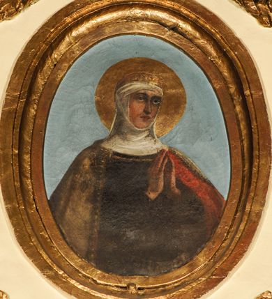 Zdjęcie nr 8: Ołtarz, architektoniczny, przyścienny, jednoosiowy, jednokondygnacyjny ze zwieńczeniem.  Mensa drewniana w postaci stołu wspartego na czterech nogach naśladujących w formie filary z impostowymi kapitelami. Retabulum posadowione na wysokim, dwudzielnym, rozczłonkowanym architektonicznie cokole, dekorowanym prostokątnymi płycinami o złoconych brzegach. Przednie ramiona cokołu ustawione ukośnie w stosunku do osi ołtarza. Na nich kolumny o kompozytowych kapitelach, wysunięte przed pilastry z pseudokorynckimi kapitelami i kanelurowanymi trzonami. Ujęte dołem parą wolut podpory dźwigają wyłamane ponad nimi, pełne belkowanie, przerwane na osi ołtarza. Na nim odcinki przyczółka w postaci wolut. Na architraw belkowania, ponad kapitelami kolumn nałożone pojedyncze liście akantu. Pomiędzy partiami przerwanego belkowania banderola rozpięta w formie półkolistego łuku, z napisem „ŚW(IĘTY) ANTONI MÓDL SIĘ ZA NAMI!". Pola odcinków przyczółka dekorowane złoconymi rocaille'ami. W polu ołtarza prostokątna nisza zamknięta łukiem koszowym z wydatnym kluczem w zwieńczeniu, ujęta złoconą, profilowaną ramą dekorowaną perełkowaniem. W niej pełnoplastyczna figura św. Antoniego Padewskiego. Wysokie, dużych rozmiarów trapezoidalne, ujęte po bokach motywem taśm zwieńczenie zamknięte fragmentem gzymsu w kształcie łuku odcinkowego, na osi którego kartusz wolutowy z motywem gorejącego serca pośrodku. Boki zwieńczenia w górnej partii ujęte parą wolut. Szczyt w formie krzyża na cokole z pary wolutek. W polu owalny obraz w złoconej, profilowanej ramie przedstawiający niezidentyfikowaną świętą. Wizerunek ujmują festony. Po bokach nastawy para figur św. Piotra i św. Pawła na wysuniętych partiach cokołu nastawy. Ołtarz w kolorze białym. Złocenia w partiach ornamentu oraz detalu architektonicznego.