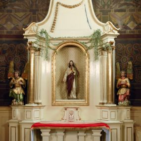 Zdjęcie nr 1: Ołtarz boczny umiejscowniony w prawym ramieniu transeptu, na jego krótszej ścianie. Architektoniczny, przyścienny, jednoosiowy, jednokondygnacyjny ze zwieńczeniem. Mensa drewniana w postaci stołu wspartego na czterech nogach naśladujących w formie filary z impostowymi, niezdobionymi kapitelami. Bez antepedium. Tabernakulum drewniane, skrzynkowe, jednodrzwiowe, w formie architektonicznej. Drzwiczki prostokątne, zamknięte półkoliście z płaskorzeźbionym, złoconym kielichem z hostią umieszczonym na srebrzonych obłokach. Jego lico artykułowane pilastrami o kanelurowanych trzonach i kompozytowych kapitelach, dźwigających wyłamany na ich osi, profilowany gzyms. Całość ujęta wolutami. Retabulum posadowione na wysokim, dwudzielnym, rozczłonkowanym architektonicznie cokole, dekorowanym prostokątnymi płycinami o złoconych brzegach. Przednie ramiona cokołu ustawione ukośnie w stosunku do osi ołtarza. Na nich złocone na całej wysokości kolumny o kompozytowych kapitelach, wysunięte przed pilastry z pseudokorynckimi kapitelami i kanelurowanymi trzonami. Podpory dźwigają wyłamane na ich osi, pełne belkowanie, przerwane na osi ołtarza. Na nim odcinki przyczółka w postaci wolut. Na architraw belkowania, ponad kapitelami kolumn, nałożone pojedyncze liście akantu. Pola odcinków przyczółka dekorowane złoconymi rocaille'ami. W polu ołtarza prostokątna nisza zamknięta łukiem półkolistym. Nisza ujęta złoconą, profilowaną ramą dekorowaną perełkowaniem. W niej pełnoplastyczna figura Chrystusa wskazującego na swoje serce. Wysokie, dużych rozmiarów zwieńczenie w kształcie łuku kotarowego o ściętym wierzchołku zamknięte łukiem wyniesionym, na osi którego kartusz wolutowy z zatkniętym u góry pojedynczym liściem akantu. Podcięte boki zwieńczenia zdobione przy brzegach złoceniem. W polu owalny obraz w złoconej, profilowanej ramie przedstawiający św. Kazimierza królewicza. Poniżej obrazu złocony, płaskorzeźbiony feston złożony z kampanul (brak jego prawej części). Na tylnych postumentach, również ustawionych ukośnie, na niewielkich cokołach, pełnoplastyczne figury klęczących na obłokach aniołów w szatach w kolorze zielonym i czerwonym, ukazanych w dynamicznych pozach. Anioł z lewej strony z dłońmi wskazującymi na piersi, prawy z dłońmi skrzyżowanymi na nich. Figury w pełni polichromowane w partiach karnacji oraz szat, gdzie dodatkowo złocone. Skrzydła utrzymane w tęczowych barwach, częściowo złocone. Wydłużone twarze z długimi wąskimi nosami oraz migdałowymi oczami. Włosy kręcone. Ołtarz pomalowany na kremowo. Złocenia w partiach ornamentu, załomach dekoracji architektonicznej, ramach obrazów oraz na kolumnach (całościowo).