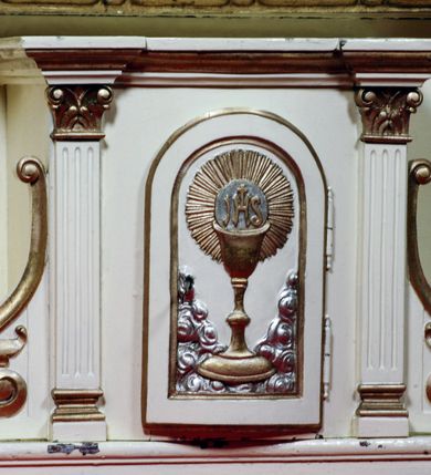 Zdjęcie nr 10: Ołtarz boczny umiejscowniony w prawym ramieniu transeptu, na jego krótszej ścianie. Architektoniczny, przyścienny, jednoosiowy, jednokondygnacyjny ze zwieńczeniem. Mensa drewniana w postaci stołu wspartego na czterech nogach naśladujących w formie filary z impostowymi, niezdobionymi kapitelami. Bez antepedium. Tabernakulum drewniane, skrzynkowe, jednodrzwiowe, w formie architektonicznej. Drzwiczki prostokątne, zamknięte półkoliście z płaskorzeźbionym, złoconym kielichem z hostią umieszczonym na srebrzonych obłokach. Jego lico artykułowane pilastrami o kanelurowanych trzonach i kompozytowych kapitelach, dźwigających wyłamany na ich osi, profilowany gzyms. Całość ujęta wolutami. Retabulum posadowione na wysokim, dwudzielnym, rozczłonkowanym architektonicznie cokole, dekorowanym prostokątnymi płycinami o złoconych brzegach. Przednie ramiona cokołu ustawione ukośnie w stosunku do osi ołtarza. Na nich złocone na całej wysokości kolumny o kompozytowych kapitelach, wysunięte przed pilastry z pseudokorynckimi kapitelami i kanelurowanymi trzonami. Podpory dźwigają wyłamane na ich osi, pełne belkowanie, przerwane na osi ołtarza. Na nim odcinki przyczółka w postaci wolut. Na architraw belkowania, ponad kapitelami kolumn, nałożone pojedyncze liście akantu. Pola odcinków przyczółka dekorowane złoconymi rocaille'ami. W polu ołtarza prostokątna nisza zamknięta łukiem półkolistym. Nisza ujęta złoconą, profilowaną ramą dekorowaną perełkowaniem. W niej pełnoplastyczna figura Chrystusa wskazującego na swoje serce. Wysokie, dużych rozmiarów zwieńczenie w kształcie łuku kotarowego o ściętym wierzchołku zamknięte łukiem wyniesionym, na osi którego kartusz wolutowy z zatkniętym u góry pojedynczym liściem akantu. Podcięte boki zwieńczenia zdobione przy brzegach złoceniem. W polu owalny obraz w złoconej, profilowanej ramie przedstawiający św. Kazimierza królewicza. Poniżej obrazu złocony, płaskorzeźbiony feston złożony z kampanul (brak jego prawej części). Na tylnych postumentach, również ustawionych ukośnie, na niewielkich cokołach, pełnoplastyczne figury klęczących na obłokach aniołów w szatach w kolorze zielonym i czerwonym, ukazanych w dynamicznych pozach. Anioł z lewej strony z dłońmi wskazującymi na piersi, prawy z dłońmi skrzyżowanymi na nich. Figury w pełni polichromowane w partiach karnacji oraz szat, gdzie dodatkowo złocone. Skrzydła utrzymane w tęczowych barwach, częściowo złocone. Wydłużone twarze z długimi wąskimi nosami oraz migdałowymi oczami. Włosy kręcone. Ołtarz pomalowany na kremowo. Złocenia w partiach ornamentu, załomach dekoracji architektonicznej, ramach obrazów oraz na kolumnach (całościowo).