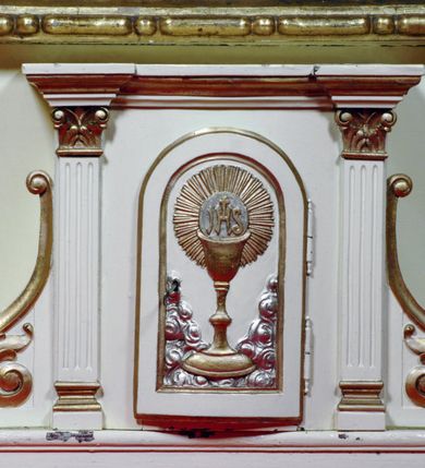 Zdjęcie nr 11: Ołtarz boczny umiejscowniony w prawym ramieniu transeptu, na jego krótszej ścianie. Architektoniczny, przyścienny, jednoosiowy, jednokondygnacyjny ze zwieńczeniem. Mensa drewniana w postaci stołu wspartego na czterech nogach naśladujących w formie filary z impostowymi, niezdobionymi kapitelami. Bez antepedium. Tabernakulum drewniane, skrzynkowe, jednodrzwiowe, w formie architektonicznej. Drzwiczki prostokątne, zamknięte półkoliście z płaskorzeźbionym, złoconym kielichem z hostią umieszczonym na srebrzonych obłokach. Jego lico artykułowane pilastrami o kanelurowanych trzonach i kompozytowych kapitelach, dźwigających wyłamany na ich osi, profilowany gzyms. Całość ujęta wolutami. Retabulum posadowione na wysokim, dwudzielnym, rozczłonkowanym architektonicznie cokole, dekorowanym prostokątnymi płycinami o złoconych brzegach. Przednie ramiona cokołu ustawione ukośnie w stosunku do osi ołtarza. Na nich złocone na całej wysokości kolumny o kompozytowych kapitelach, wysunięte przed pilastry z pseudokorynckimi kapitelami i kanelurowanymi trzonami. Podpory dźwigają wyłamane na ich osi, pełne belkowanie, przerwane na osi ołtarza. Na nim odcinki przyczółka w postaci wolut. Na architraw belkowania, ponad kapitelami kolumn, nałożone pojedyncze liście akantu. Pola odcinków przyczółka dekorowane złoconymi rocaille'ami. W polu ołtarza prostokątna nisza zamknięta łukiem półkolistym. Nisza ujęta złoconą, profilowaną ramą dekorowaną perełkowaniem. W niej pełnoplastyczna figura Chrystusa wskazującego na swoje serce. Wysokie, dużych rozmiarów zwieńczenie w kształcie łuku kotarowego o ściętym wierzchołku zamknięte łukiem wyniesionym, na osi którego kartusz wolutowy z zatkniętym u góry pojedynczym liściem akantu. Podcięte boki zwieńczenia zdobione przy brzegach złoceniem. W polu owalny obraz w złoconej, profilowanej ramie przedstawiający św. Kazimierza królewicza. Poniżej obrazu złocony, płaskorzeźbiony feston złożony z kampanul (brak jego prawej części). Na tylnych postumentach, również ustawionych ukośnie, na niewielkich cokołach, pełnoplastyczne figury klęczących na obłokach aniołów w szatach w kolorze zielonym i czerwonym, ukazanych w dynamicznych pozach. Anioł z lewej strony z dłońmi wskazującymi na piersi, prawy z dłońmi skrzyżowanymi na nich. Figury w pełni polichromowane w partiach karnacji oraz szat, gdzie dodatkowo złocone. Skrzydła utrzymane w tęczowych barwach, częściowo złocone. Wydłużone twarze z długimi wąskimi nosami oraz migdałowymi oczami. Włosy kręcone. Ołtarz pomalowany na kremowo. Złocenia w partiach ornamentu, załomach dekoracji architektonicznej, ramach obrazów oraz na kolumnach (całościowo).