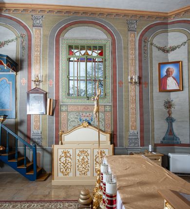 Zdjęcie nr 4: Ambona wisząca, przyścienna. Kosz na planie kwadratu o wklęsłych narożach; na profilowanej podstawie, cokół wydatny zdobiony wklęsłym puklowaniem; u spodu szyszka. Ścianki kosza dekorowane malowanymi płycinami, w formie stojących prostokątów z wklęsłymi narożami, w polu środkowym marmoryzowane zdobienia. Ścianki wklęsłe zdobione rocaille'm. Parapet w formie profilowanego, pełnego belkowania z fryzem dekorowanym motywem roślinnym. Na parapecie, w lewym narożu pulpit; od frontu zdobiony płyciną z rocaille'm. Zaplecek w formie wydłużonego, stojącego prostokąta, w polu z malowaną płyciną w kształcie stojącego prostokąta zamkniętego łukiem nadwieszonym. Płycina marmoryzowana i obwiedziona złotą ramką. Baldachim na planie kwadratu z wklęsłymi narożami; ujęty lambrekinem, zamknięty gzymsem. U spodu rzeźbiona gołębica Ducha Świętego w glorii. Wejście na ambonę od strony prezbiterium, w postaci pięciostopniowych schodów z balustradą. Struktura polichromowana na niebiesko, profile i ornamenty złocone.
