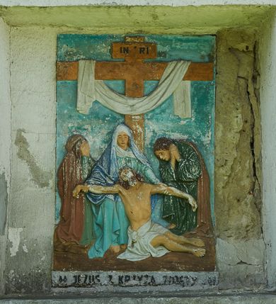 Zdjęcie nr 4: Stacje drogi krzyżowej zamontowane w prostokątnych wnękach muru przykościelnego. Kompozycje kilkupostaciowe ukazane na jednolitym, błękitnym tle. Nad każdą stacją krzyżową umieszczone proste, drewniane krzyżyki. U dołu stacji rzeźbione, malowane na czarno inskrypcje:
1. „+JEZUS NA ŚMIERĆ OSĄDZONY+”;
2. „JEZUS KRZYŻEM OBCIĄŻONY+”;
3. „+JEZUS PIERWSZY RAZ UPADA+”;
4. „+JEZUS SPOTYKA MATKĘ SWĄ+”;
5. „CYRENEJCZYK POMAGA JEZUSOWI”;
6. „WERONIKA OCIERA TWARZ JEZUSA”;
7. „JEZUS DRUGI RAZ UPADA”(inskrypcja prawie nieczytelna);
8. „JEZUS POCIESZA NIEWIASTY”;
9. „++JEZUS TRZECI RAZ UPADA++”;
10. „++JEZUS Z SZAT OBNAŻONY++”;
11. „+JEZUS DO KRZYŻA PRZYBITY+”;
12. „INRI / ++JEZUS NA KRZYŻU UMIERA” (inskrypcja prawie nieczytelna);
13. „INRI / ++JEZUS Z KRZYŻA ZDJĘTY++”;
14. (Brak fotografii).

