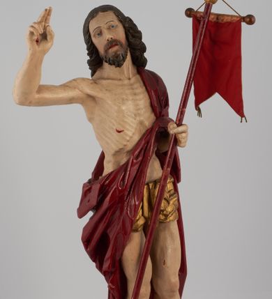 Zdjęcie nr 1: Rzeźba pełna, ustawiona na niskim, kwadratowym, profilowanym cokole. Chrystus ukazany frontalnie, stojący na kawałku zielonej murawy, w kontrapoście, z głową zwróconą w prawo. W lewej, ugiętej ręce trzyma chorągiew; prawa, uniesiona jest wysoko w geście błogosławieństwa. Twarz pociągła, okolona brodą, z na wpół przymkniętymi oczami; włosy długie, kręcone opadają na ramiona. Ciało wychudzone, z zaznaczonymi śladami męki i podkreśloną linią żeber. Przez lewe ramię przerzucony czerwony płaszcz spływający na plecy i z przodu na lewe przedramię; na biodrach złocone  perizonium, ciasno oplecione. Polichromia ciała jest naturalistyczna, perizonium złocone.