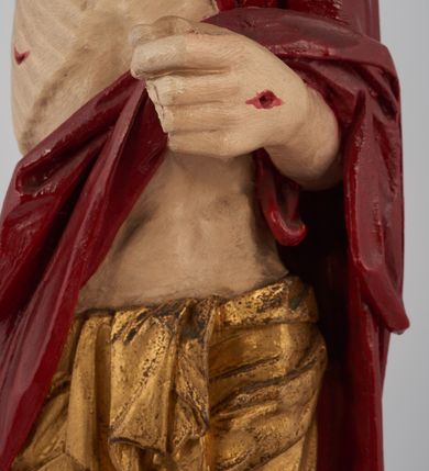 Zdjęcie nr 6: Rzeźba pełna, ustawiona na niskim, kwadratowym, profilowanym cokole. Chrystus ukazany frontalnie, stojący na kawałku zielonej murawy, w kontrapoście, z głową zwróconą w prawo. W lewej, ugiętej ręce trzyma chorągiew; prawa, uniesiona jest wysoko w geście błogosławieństwa. Twarz pociągła, okolona brodą, z na wpół przymkniętymi oczami; włosy długie, kręcone opadają na ramiona. Ciało wychudzone, z zaznaczonymi śladami męki i podkreśloną linią żeber. Przez lewe ramię przerzucony czerwony płaszcz spływający na plecy i z przodu na lewe przedramię; na biodrach złocone  perizonium, ciasno oplecione. Polichromia ciała jest naturalistyczna, perizonium złocone.