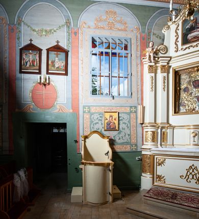 Zdjęcie nr 3: Konfesjonał usytuowany w nawie głównej, przy ścianie północnej. Podstawa na planie zbliżonym do kwadratu, z przodu zakończona linią wklęsło-wypukłą. Drzwi zamykające wejście do siedziska wypukłe, zakończone profilowanym gzymsem, ujęte po bokach ukośnie ustawionymi lizenami. Boczne, występujące ku górze ścianki ograniczające siedzisko zwieńczone fantazyjnymi łukami wklęsło-wypukłymi zakończonymi ślimacznicami. Ściana zaplecka zakończona profilowanym gzymsem w kształcie łuku wklęsło-wypukłego. Po bokach konfesjonału dostawione, wolnostojące klęczniki w formie prostopadłościanów. W ściankach flankujących z boków siedzisko księdza prześwity z grubą kratą, w kształcie stojącego prostokąta, zamkniętego łukiem ostrym, ujęte prostą ramą. Konfesjonał polichromowany w kolorze beżowym, profilowania złocone. 

