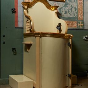 Zdjęcie nr 1: Konfesjonał usytuowany w nawie głównej, przy ścianie północnej. Podstawa na planie zbliżonym do kwadratu, z przodu zakończona linią wklęsło-wypukłą. Drzwi zamykające wejście do siedziska wypukłe, zakończone profilowanym gzymsem, ujęte po bokach ukośnie ustawionymi lizenami. Boczne, występujące ku górze ścianki ograniczające siedzisko zwieńczone fantazyjnymi łukami wklęsło-wypukłymi zakończonymi ślimacznicami. Ściana zaplecka zakończona profilowanym gzymsem w kształcie łuku wklęsło-wypukłego. Po bokach konfesjonału dostawione, wolnostojące klęczniki w formie prostopadłościanów. W ściankach flankujących z boków siedzisko księdza prześwity z grubą kratą, w kształcie stojącego prostokąta, zamkniętego łukiem ostrym, ujęte prostą ramą. Konfesjonał polichromowany w kolorze beżowym, profilowania złocone. 

