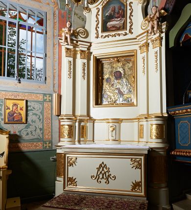 Zdjęcie nr 8: Nastawa ołtarzowa architektoniczna, jednoosiowa, jednokondygnacyjna ze zwieńczeniem. Ołtarz prostopadłościenny z kamienną mensą, z portatylem i kamiennymi bokami. Antepedium drewniane, obwiedzione profilowaną ramą z narożami wypełnionymi stylizowanymi liśćmi i wypukło rzeźbionym imieniem Marii pośrodku. Tabernakulum na planie półkola, wbudowane w strefę cokołu. Nastawa wsparta na podwójnym cokole, flankowanym masywnymi, półkolumnami, ustawionymi pod kątem; w drugiej strefie zdwojonymi, wspierającymi dwie pary ukośnie ustawionych pilastrów. W polu głównym znajduje się obraz Matki Boskiej z Dzieciątkiem z XVI wieku, a na zasuwie  dwa obrazy: pierwszy – św. Mikołaja z połowy XIX wieku, drugi – św. Józefa z 1901 roku, namalowany przez Antoniego Gramatykę. Zwieńczenie w kształcie stojącego prostokąta, zamkniętego gzymsem o łuku wklęsło-wypukłym, po bokach ujęte ukośnie dostawionymi spływami wolutowymi. U szczytu zwieńczenia muszla palmetowa oraz dwa wazoniki na skrajach gzymsu. W polu zwieńczenia obraz z przedstawieniem Nauczania Marii, otoczony wicią roślinną. W partii zwieńczenia na filarach usadzone są rzeźby aniołków. Płyciny cokołów zdobi złocona, ryta dekoracja roślinna. Na trzonach pilastrów znajdują się sięgające do jednej trzeciej wysokości girlandy kwiatów. Struktura polichromowana na kolor jasnobeżowy, detale i ornamentyka złocone. Portatyl kamienny, kwadratowy z napisem na przyklejonej kartce papieru  „Anno Domini 1969 die 2 Maii excelentissimus Julianus Groblicki episcopus titularis Philadelphiensis in Arabia, auxiliuris Cracoviensis tabulam hanc consecravit et reliquis sanctorum martyrum Brittcii episcopi in et inclusit necnon sancti Prosperas”.
