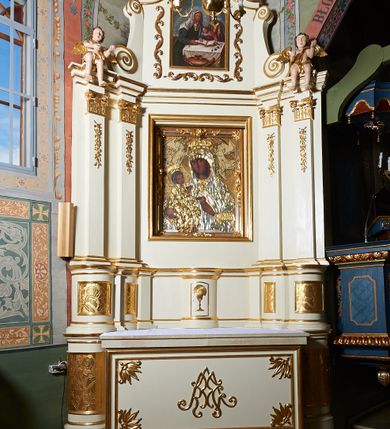 Zdjęcie nr 1: Nastawa ołtarzowa architektoniczna, jednoosiowa, jednokondygnacyjna ze zwieńczeniem. Ołtarz prostopadłościenny z kamienną mensą, z portatylem i kamiennymi bokami. Antepedium drewniane, obwiedzione profilowaną ramą z narożami wypełnionymi stylizowanymi liśćmi i wypukło rzeźbionym imieniem Marii pośrodku. Tabernakulum na planie półkola, wbudowane w strefę cokołu. Nastawa wsparta na podwójnym cokole, flankowanym masywnymi, półkolumnami, ustawionymi pod kątem; w drugiej strefie zdwojonymi, wspierającymi dwie pary ukośnie ustawionych pilastrów. W polu głównym znajduje się obraz Matki Boskiej z Dzieciątkiem z XVI wieku, a na zasuwie  dwa obrazy: pierwszy – św. Mikołaja z połowy XIX wieku, drugi – św. Józefa z 1901 roku, namalowany przez Antoniego Gramatykę. Zwieńczenie w kształcie stojącego prostokąta, zamkniętego gzymsem o łuku wklęsło-wypukłym, po bokach ujęte ukośnie dostawionymi spływami wolutowymi. U szczytu zwieńczenia muszla palmetowa oraz dwa wazoniki na skrajach gzymsu. W polu zwieńczenia obraz z przedstawieniem Nauczania Marii, otoczony wicią roślinną. W partii zwieńczenia na filarach usadzone są rzeźby aniołków. Płyciny cokołów zdobi złocona, ryta dekoracja roślinna. Na trzonach pilastrów znajdują się sięgające do jednej trzeciej wysokości girlandy kwiatów. Struktura polichromowana na kolor jasnobeżowy, detale i ornamentyka złocone. Portatyl kamienny, kwadratowy z napisem na przyklejonej kartce papieru  „Anno Domini 1969 die 2 Maii excelentissimus Julianus Groblicki episcopus titularis Philadelphiensis in Arabia, auxiliuris Cracoviensis tabulam hanc consecravit et reliquis sanctorum martyrum Brittcii episcopi in et inclusit necnon sancti Prosperas”.