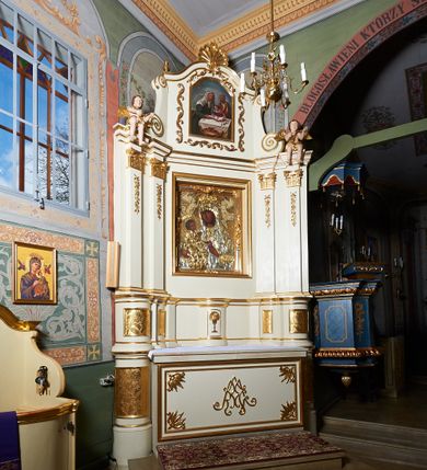 Zdjęcie nr 6: Nastawa ołtarzowa architektoniczna, jednoosiowa, jednokondygnacyjna ze zwieńczeniem. Ołtarz prostopadłościenny z kamienną mensą, z portatylem i kamiennymi bokami. Antepedium drewniane, obwiedzione profilowaną ramą z narożami wypełnionymi stylizowanymi liśćmi i wypukło rzeźbionym imieniem Marii pośrodku. Tabernakulum na planie półkola, wbudowane w strefę cokołu. Nastawa wsparta na podwójnym cokole, flankowanym masywnymi, półkolumnami, ustawionymi pod kątem; w drugiej strefie zdwojonymi, wspierającymi dwie pary ukośnie ustawionych pilastrów. W polu głównym znajduje się obraz Matki Boskiej z Dzieciątkiem z XVI wieku, a na zasuwie  dwa obrazy: pierwszy – św. Mikołaja z połowy XIX wieku, drugi – św. Józefa z 1901 roku, namalowany przez Antoniego Gramatykę. Zwieńczenie w kształcie stojącego prostokąta, zamkniętego gzymsem o łuku wklęsło-wypukłym, po bokach ujęte ukośnie dostawionymi spływami wolutowymi. U szczytu zwieńczenia muszla palmetowa oraz dwa wazoniki na skrajach gzymsu. W polu zwieńczenia obraz z przedstawieniem Nauczania Marii, otoczony wicią roślinną. W partii zwieńczenia na filarach usadzone są rzeźby aniołków. Płyciny cokołów zdobi złocona, ryta dekoracja roślinna. Na trzonach pilastrów znajdują się sięgające do jednej trzeciej wysokości girlandy kwiatów. Struktura polichromowana na kolor jasnobeżowy, detale i ornamentyka złocone. Portatyl kamienny, kwadratowy z napisem na przyklejonej kartce papieru  „Anno Domini 1969 die 2 Maii excelentissimus Julianus Groblicki episcopus titularis Philadelphiensis in Arabia, auxiliuris Cracoviensis tabulam hanc consecravit et reliquis sanctorum martyrum Brittcii episcopi in et inclusit necnon sancti Prosperas”.
