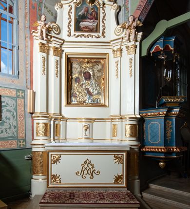 Zdjęcie nr 4: Nastawa ołtarzowa architektoniczna, jednoosiowa, jednokondygnacyjna ze zwieńczeniem. Ołtarz prostopadłościenny z kamienną mensą, z portatylem i kamiennymi bokami. Antepedium drewniane, obwiedzione profilowaną ramą z narożami wypełnionymi stylizowanymi liśćmi i wypukło rzeźbionym imieniem Marii pośrodku. Tabernakulum na planie półkola, wbudowane w strefę cokołu. Nastawa wsparta na podwójnym cokole, flankowanym masywnymi, półkolumnami, ustawionymi pod kątem; w drugiej strefie zdwojonymi, wspierającymi dwie pary ukośnie ustawionych pilastrów. W polu głównym znajduje się obraz Matki Boskiej z Dzieciątkiem z XVI wieku, a na zasuwie  dwa obrazy: pierwszy – św. Mikołaja z połowy XIX wieku, drugi – św. Józefa z 1901 roku, namalowany przez Antoniego Gramatykę. Zwieńczenie w kształcie stojącego prostokąta, zamkniętego gzymsem o łuku wklęsło-wypukłym, po bokach ujęte ukośnie dostawionymi spływami wolutowymi. U szczytu zwieńczenia muszla palmetowa oraz dwa wazoniki na skrajach gzymsu. W polu zwieńczenia obraz z przedstawieniem Nauczania Marii, otoczony wicią roślinną. W partii zwieńczenia na filarach usadzone są rzeźby aniołków. Płyciny cokołów zdobi złocona, ryta dekoracja roślinna. Na trzonach pilastrów znajdują się sięgające do jednej trzeciej wysokości girlandy kwiatów. Struktura polichromowana na kolor jasnobeżowy, detale i ornamentyka złocone. Portatyl kamienny, kwadratowy z napisem na przyklejonej kartce papieru  „Anno Domini 1969 die 2 Maii excelentissimus Julianus Groblicki episcopus titularis Philadelphiensis in Arabia, auxiliuris Cracoviensis tabulam hanc consecravit et reliquis sanctorum martyrum Brittcii episcopi in et inclusit necnon sancti Prosperas”.
