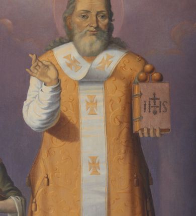 Zdjęcie nr 2: Obraz w kształcie stojącego prostokąta przedstawiający św. Mikołaja. Święty został ukazany frontalnie, całopostaciowo w centrum kompozycji. W lewej ręce trzyma księgę, na której ustawione są trzy złote kule; prawą ręką czyni gest błogosławieństwa. Święty Mikołaj ma szeroką twarz, okoloną siwą, średniej długości brodą, nos długi i wąski, oczy małe, skierowane w dal. Włosy długie, siwe, z przedziałkiem pośrodku, opadające lokami na plecy. Ubrany jest w szaty biskupie: białą albę, złoty ornat, palice na bokach i omoforion, wokół głowy ma kolisty nimb. Po lewej stronie znajduje się chłopiec w postawie stojącej, który trzyma w dłoniach złotą misę, a na niej kielich i dwa małe puchary. Ma owalną twarz z wyraźnie zaznaczonym podbródkiem, długi i szeroki nos, małe oczy oraz długie, falowane włosy opadające na plecy. Ubrany jest w zieloną tunikę do kolan z podwiniętymi szerokimi rękawami oraz czerwony, zwiewny płaszcz spięty małą broszą na prawym ramieniu. Po prawej stronie ukazano szaflik z trójką półnagich małych dzieci. Księga trzymana w rękach przez św. Mikołaja ma czerwoną obwolutę i jest spięta dwiema klamrami, na okładce znajduje się monogram IHS zwieńczony krzyżykiem, a poniżej gorejące serce. Całość została ukazana we wnętrzu architektonicznym, górną część obrazu pokrywa pochmurne niebo. Kolorystyka jasna i stonowana.
