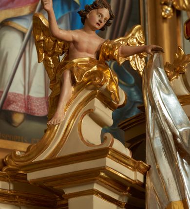 Zdjęcie nr 3: Ołtarz murowany, w formie prostopadłościanu. Mensa drewniana z portatylem. Antependium złocone, w formie leżącego prostokąta w profilowanej ramie; w polu środkowym znajduje się monogram IHS, a w narożach rozety. Tabernakulum z wypukłą ścianką frontową, po bokach ujęte jest spływami wolutowymi na cokołach, dekorowanymi ornamentem rocaille'owym. Drzwiczki w formie stojącego prostokąta zamkniętego łukiem nadwieszonym; w polu mają płaskorzeźbiony kielich wśród obłoków, z hostią w glorii. Tron wystawienia architektoniczny, trójosiowy, jednokondygnacyjny ze zwieńczeniem. Oś środkowa wypukła, wyższa niż boczne, zamknięta jest profilowanym gzymsem. Tron ujmują dwie pary kolumn na ukośnie ustawionych cokołach. Podpory dźwigają pełne belkowanie wyłamane na ich osi. Na linii wewnętrznych kolumn znajduje się przerywany przyczółek z siedzącymi aniołkami podtrzymującymi srebrzony paludament. Zwieńczenie ma formę cokołu, ujętego spływami wolutowymi; na którym ustawiona jest księga zamknięta na siedem pięczęci, na niej postawiona srebrzona waza z kwiatami oraz biały baranek z chorągwią paschalną. Na cokołach wspierających kolumny znajdują się rocaille'owe płyciny z lusterkami. Oś środkowa flankowana jest kwiatowymi zwisami. Tron wystawienia posiada obrotową wnękę z gzymsem wieńczącym, ozdobionym lambrekinem: awers wklęsły, posrebrzany, z rytym monogramem IHS oraz krzyżem i wiązkami promieni, powyżej rzeźbiony rocaille; rewers w kształcie niszy, dekorowany rytą, złoconą kratką i rzeźbionym, srebrzonym rocaille'm. Struktura polichromowana na beżowo, kolumny, ornamentyka i profilowania złocone, detale srebrzone. Za ołtarzem, na wschodniej ścianie prezbiterium wisi obraz św. Erazma w złoconej, profilowanej ramie, w formie stojącego prostokąta, zamkniętego nadwieszonym łukiem półkolistym. Rama dekorowana jest w narożach i na bokach stylizowanymi palmetami. Nad obrazem, w podłuczu znajduje się płaskorzeźbiona korona otwarta z dwoma piórami.