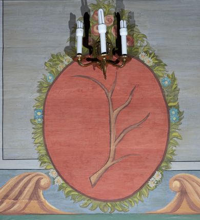 Zdjęcie nr 7: Polichromia umieszczona na ścianach prezbiterium naśladuje architekturę. Składa się z czterech prostokątnych płaszczyzn, zamkniętych od góry półkoliście, ujętych w pasach w kolorze oliwkowozielonym i czerwonym, oddzielonych od siebie pilastrami. Trzony pilastrów dekorowane są ornamentem ze stylizowanych liści i kwiatów; bazy i kapitele są z motywami zoomorficznymi i roślinnymi w kolorze szarym. W dolnych częściach płaszczyzn, przy ołtarzu namalowano kwiatony, w górnych częściach kwieciste girlandy. Na ścianie wschodniej znajduje się namalowana supraporta z częściowo zachowanym napisem „AEDIFICATUM ET DEDIC(TUM)?”. Wokół obrazu św. Erazma zawieszonego na ścianie wschodniej namalowano pseudorokokową ramę w kolorze złotym. Dołem biegnie pas lamperii w kolorze białym. Na stropie, w centralnej części kompozycji ukazana jest scena Zwiastowania, namalowana w technice olejnej na płótnie. Po lewej stronie znajduje się Matka Boska w różowej sukni i niebieskim płaszczu, a po prawej św. Archanioł Gabriel w białej sukni i ugrowym płaszczu. Nad nimi w promienistej glorii została ukazana gołębica Ducha Świętego. Scena namalowana jest w architektonicznym wnętrzu. Tło jasnoszare. Obraz ujmuje bordiura z powtarzających się elementów geometryczno-roślinnych. Analogicznie jak w prezbiterium w nawie głównej znajduje się pięć architektonicznych płaszczyzn. Polichromie umieszczone na ścianach południowej i północnej stanowią swoje lustrzane odbicie. W górnej części płaszczyzn namalowano girlandy oraz dwie tarcze herbowe w supraportach. Dodatkowo w płaszczyznach podokiennych namalowano wijącą się dywanową kompozycję ze stylizowanych liści i kwiatów. Pod chórem umieszczone są dwa zacheusze w pseudorokokowej ramie. U dołu nawę obiega pas lamperii w kolorze zielonym. Na stropie, w części centralnej znajduje się obraz przedstawiający Przemienienie Pańskie. Tło jasnoszare. Obraz ujmuje bordiura z powtarzających się elementów geometryczno-roślinnych.