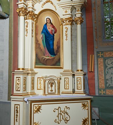 Zdjęcie nr 4: Nastawa ołtarzowa architektoniczna, jednoosiowa, jednokondygnacyjna ze zwieńczeniem. Ołtarz prostopadłościenny z kamienną mensą z portatylem. Antepedium drewniane obwiedzione profilowaną ramą z narożami wypełnionymi stylizowanymi liśćmi i wypukło rzeźbionym monogramem IHS pośrodku. Tabernakulum w formie prostopadłościennej skrzynki, flankowane na przodzie parą kolumienek, zamknięte od góry profilowanym gzymsem. Drzwiczki w kształcie stojącego prostokąta z płaskorzeźbionym kielichem z hostią w glorii. Nastawa wsparta na podwójnym, ukośnie ustawionym cokole, podtrzymującym parę zdwojonych filarów i stojących przed nimi parę kolumn. Podpory wspierają imposty i przerywany, wolutowy przyczółek, z usadzoną nań parą aniołków. W polu głównym, w prostokątnej ramie, zamkniętej łukiem nadwieszonym znajduje się obraz „Najświętsze Serce Pana Jezusa” z końca XIX wieku oraz obraz „Trójca Święta” z 1784 roku na zasuwie. Zwieńczenie w kształcie wklęsło-wypukłym, zamkniętym gzymsem utworzonym z dwóch wolut spiętych pośrodku muszlą palmetową. W polu środkowym obraz „Stygmatyzacja św. Franciszka”. W partii cokołu prostokątne płyciny zamknięte profilowanymi ramami z dekoracją floralną w polu, a górne części filarów zdobione ornamentem akantowym. Podpory ustawione na bazach, trzony gładkie, kapitele kompozytowe. Imposty zdobione stylizowanymi rozetami. Struktura polichromowana na kolor jasnobeżowy, detale i ornamentyka złocone.

