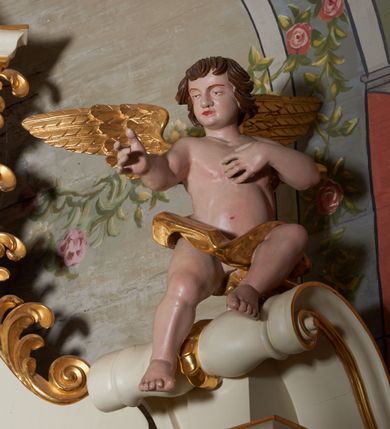 Zdjęcie nr 9: Nastawa ołtarzowa architektoniczna, jednoosiowa, jednokondygnacyjna ze zwieńczeniem. Ołtarz prostopadłościenny z kamienną mensą z portatylem. Antepedium drewniane obwiedzione profilowaną ramą z narożami wypełnionymi stylizowanymi liśćmi i wypukło rzeźbionym monogramem IHS pośrodku. Tabernakulum w formie prostopadłościennej skrzynki, flankowane na przodzie parą kolumienek, zamknięte od góry profilowanym gzymsem. Drzwiczki w kształcie stojącego prostokąta z płaskorzeźbionym kielichem z hostią w glorii. Nastawa wsparta na podwójnym, ukośnie ustawionym cokole, podtrzymującym parę zdwojonych filarów i stojących przed nimi parę kolumn. Podpory wspierają imposty i przerywany, wolutowy przyczółek, z usadzoną nań parą aniołków. W polu głównym, w prostokątnej ramie, zamkniętej łukiem nadwieszonym znajduje się obraz „Najświętsze Serce Pana Jezusa” z końca XIX wieku oraz obraz „Trójca Święta” z 1784 roku na zasuwie. Zwieńczenie w kształcie wklęsło-wypukłym, zamkniętym gzymsem utworzonym z dwóch wolut spiętych pośrodku muszlą palmetową. W polu środkowym obraz „Stygmatyzacja św. Franciszka”. W partii cokołu prostokątne płyciny zamknięte profilowanymi ramami z dekoracją floralną w polu, a górne części filarów zdobione ornamentem akantowym. Podpory ustawione na bazach, trzony gładkie, kapitele kompozytowe. Imposty zdobione stylizowanymi rozetami. Struktura polichromowana na kolor jasnobeżowy, detale i ornamentyka złocone.

