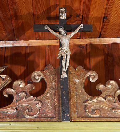 Zdjęcie nr 2: Komoda prostopadłościenna, ustawiona na wysokim cokole, po bokach z dwiema jednodrzwiowymi szafkami, pośrodku pięć niskich szuflad na ornaty. Nakryta blatem o profilowanej od przodu krawędzi. Drzwiczki osadzone są na metalowych, kutych zawiasach. Szuflady posiadają lica z profilowanymi listwami i parami kulistych, toczonych uchwytów. Drzwiczki zewnętrznych szafek posiadają profilowane listwy przymykowe. Nadstawka dwudrzwiowa, w dolnej części z czterema, niskimi szufladami, obitymi profilowanymi listwami, z toczonymi, kulistymi uchwytami; zwieńczona profilowanym gzymsem. Drzwi osadzone na metalowych, kutych zawiasach pasowych, w polu zdobione malowanymi płycinami w kształcie stojącego prostokąta o ściętych narożach. Zwieńczenie w formie rzeźbionej wici roślinnej miejscami wywiniętej kartuszowo. Pośrodku szczytu osadzony jest krucyfiks z figurą Chrystusa w typie Cristo morte. Szafa malowana olejno w kolorze jasnoniebieskim, detal na niebiesko, listwy na beżowo.