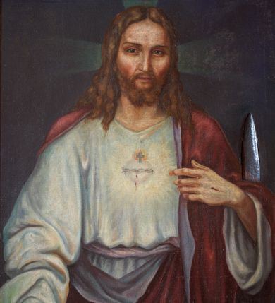 Zdjęcie nr 1: Obraz w kształcie stojącego prostokąta ujęty w złoconą, dekorowaną ornamentem roślinnym ramę. W centrum kompozycji ukazany Chrystus w półpostaci, frontalnie, z lewą ręką wskazującą na gorejące na piersi serce, prawą spuszczoną w dół. Ubrany w długą, białą suknię z długimi rękawami oraz czerwony płaszcz, założony na plecy. Na piersi gorejące serce na tle promienistej glorii, z zatkniętym u szczytu małym krzyżykiem, oplecione koroną cierniową. Twarz podłużna z długim i wąskim nosem, małymi oczami, ze wzrokiem skierowanym na wprost, okolona krótką brodą, rozdzieloną na dwa pukle oraz długimi włosami, z przedziałkiem pośrodku, spływającymi długimi puklami na ramiona i plecy. Na dłoniach widoczne ślady męki.
Tło jednolite, ciemnobrązowe. Kolorystyka ciemna. W prawym, dolnym narożu sygnatura „R(ok) 1935/ ST(ANISŁAW) CIĘŻADLIK”.