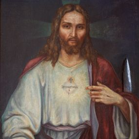 Zdjęcie nr 1: Obraz w kształcie stojącego prostokąta ujęty w złoconą, dekorowaną ornamentem roślinnym ramę. W centrum kompozycji ukazany Chrystus w półpostaci, frontalnie, z lewą ręką wskazującą na gorejące na piersi serce, prawą spuszczoną w dół. Ubrany w długą, białą suknię z długimi rękawami oraz czerwony płaszcz, założony na plecy. Na piersi gorejące serce na tle promienistej glorii, z zatkniętym u szczytu małym krzyżykiem, oplecione koroną cierniową. Twarz podłużna z długim i wąskim nosem, małymi oczami, ze wzrokiem skierowanym na wprost, okolona krótką brodą, rozdzieloną na dwa pukle oraz długimi włosami, z przedziałkiem pośrodku, spływającymi długimi puklami na ramiona i plecy. Na dłoniach widoczne ślady męki.
Tło jednolite, ciemnobrązowe. Kolorystyka ciemna. W prawym, dolnym narożu sygnatura „R(ok) 1935/ ST(ANISŁAW) CIĘŻADLIK”.