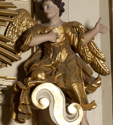 Zdjęcie nr 17: Ołtarz typu architektonicznego, jednokondygnacyjny, jednoosiowy, z bramkami i ze zwieńczeniem w formie glorii. Mensa prostopadłościenna, na ściance przedniej zdobiona rzędem płycin w kształcie stojącego prostokąta, zamkniętych łukiem nadwieszonym. W polu środkowej płyciny malowany krzyż grecki, w pozostałych gałązki białych lilii. Tabernakulum w formie prostopadłościennej skrzynki, z częścią środkową wysuniętą do przodu, zamknięte od góry profilowanym gzymsem w kształcie łuku nadwieszonego. Drzwiczki metalowe, pośrodku dekorowane płyciną w kształcie stojącego prostokąta, zamkniętego łukiem nadwieszonym, w polu kielich z hostią, kłosy zboża i kiście winogron. Nad tabernakulum tron wystawienia na tle promienistej glorii z monogramem IHS pośrodku, po bokach flankowany przez parę aniołków usadzonych na wolutach. Retabulum ustawione na wysokim cokole, ujęte parą zdwojonych, ukośnie ustawionych pilastrów podtrzymujących przerywane belkowanie, na którym usadzona para putt. Trzony pilastrów zdobione kanelowaniem, kapitele stylizowane, kompozytowe. Putto po lewej stronie z otwartą księgą, w której znajduje się napis: „Assu/pta / est / Maria / in / Caelum”. W polu głównym nastawy, na wysokości dwóch trzecich obraz z przedstawieniem Wniebowzięcia Najświętszej Marii Panny. Po bokach obrazu para rzeźbionych aniołków. W zwieńczeniu płaskorzeźba Boga Ojca na tle promienistej glorii. Drzwiczki bramek zdobione płyciną w kształcie stojącego prostokąta, zamkniętą od góry łukiem nadwieszonym. Zwieńczenie bramek zdobione festonem z liści wawrzynu, zakończone niskim cokołem, na którym ustawione rzeźby: po lewej św. Jana Chrzciciela, po prawej św. Kazimierza. Uszy ażurowe w postaci ornamentu rocaille'owego. Struktura ołtarza w kolorze beżowym, ornamentyka, detale i profilowania złocone.