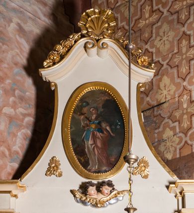 Zdjęcie nr 7: Ołtarz architektoniczny, jednoosiowy, jednokondygnacyjny ze zwieńczeniem, z uszami. Retabulum ustawione na prostopadłościennej mensie ołtarzowej z antepedium, zdobionym czterema prostokątnymi płycinami oddzielonymi kanelowanymi lizenami. Tabernakulum w kształcie prostopadłościennej skrzynki na wysokim cokole, zamkniętej od góry płaskim daszkiem, na którym miejsce na prosty tron do wystawiania monstrancji. Przednia ścianka tabernakulum zamknięta od góry gzymsem w formie łuku nadwieszonego. Drzwiczki w formie stojącego prostokąta zamkniętego łukiem półkolistym. W polu, obwiedzionym ramą o analogicznym kształcie płaskorzeźbiony krzyż z podstawą. Ustawiona na mensie nastawa wsparta na cokole z wyodrębnionymi po bokach dwoma postumentami, wyżej ujęta parą pilastrów, o trzonach ozdobionych płycinami i u góry zwisami ze stylizowanych kampanul, z nałożonymi u szczytu konsolkami pełniącymi funkcję kapiteli, które wspierają odcinki przerwanego belkowania. W polu głównym obraz Najświętszego Serca Pana Jezusa w kształcie pionowego prostokąta. Zwieńczenie  w ogólnym zarysie w formie trapezu, o bokach zaakcentowanych wklęsłymi łukami odcinkowymi, zamknięte od góry dwiema wolutkami, spiętymi u szczytu muszlą palmetową i ozdobionymi wicią z różami. W polu owalny obraz z przedstawieniem św. Tekli. Poniżej dwie uskrzydlone główki aniołków. Uszy z wici i motywów ornamentu rocaille&#039;owego. Struktura ołtarza w kolorze białym, detale i ornamentyka złocone.